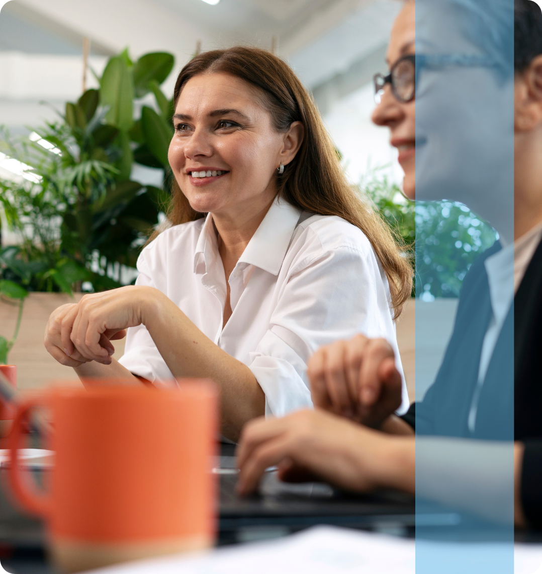A professional woman smiling during a business strategy meeting, representing the Projects and Tendering recruitment team.