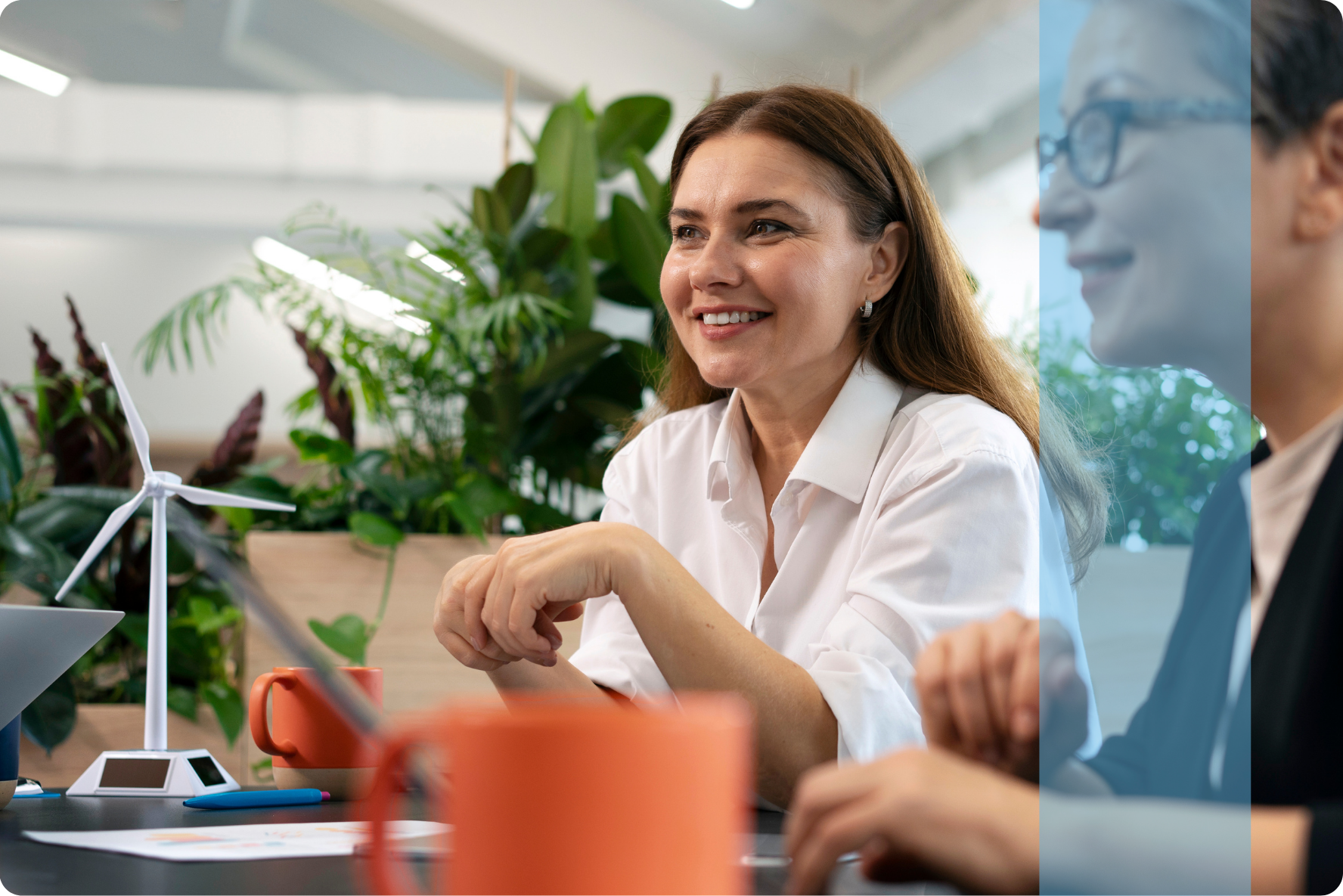 A professional woman smiling during a business strategy meeting, representing the Projects and Tendering recruitment team.
