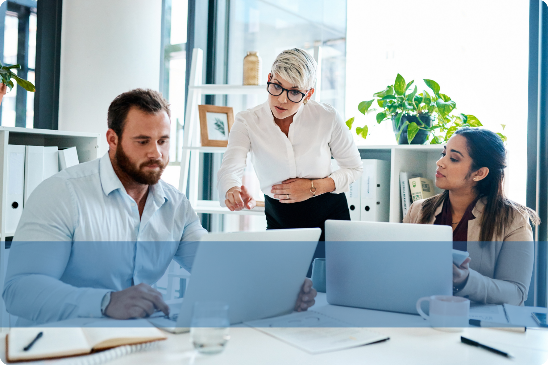 Professionals engaging in a discussion at a desk, representing the Konnekt IT recruitment team analysing technical candidate pipelines.
